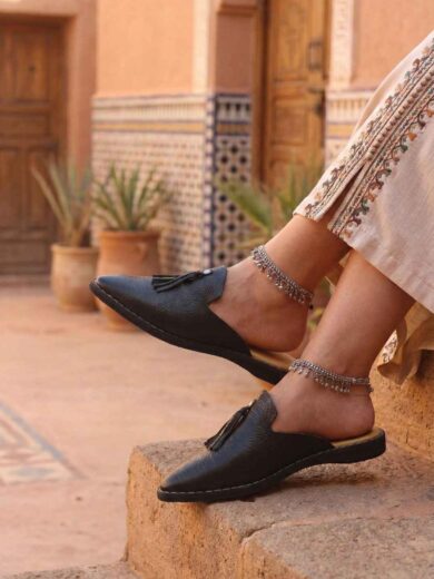 Pair of The Malika, Women's Black Leather Babouche with a pointed toe.