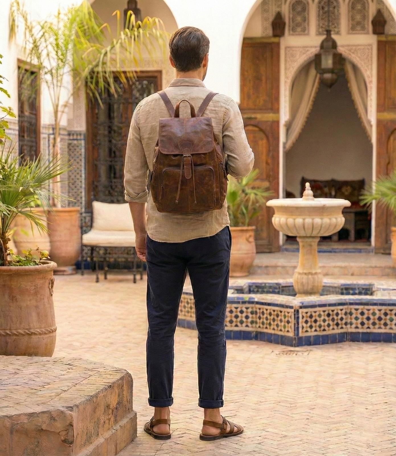 Front view of The Explorer, a Handmade Leather Backpack showing the buckles and pockets.