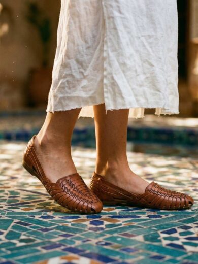 Woman wearing handwoven Moroccan leather ouarache sandals on zellige tile floor