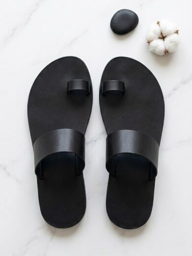 Flat lay of The Essaouira black toe ring sandals by Kasba Leather on white marble